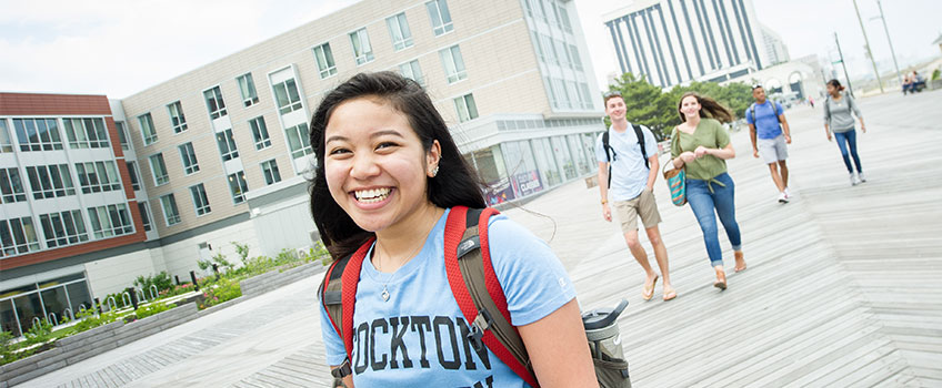 smiling student walking on the Atlantic City boardwalk