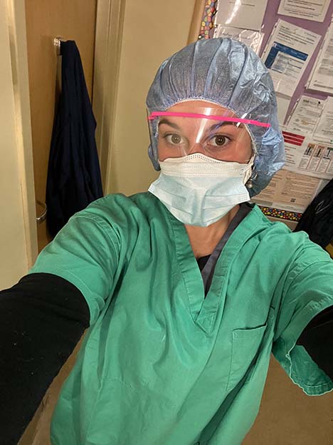 Natalie Giovinazzi wearing scrubs and a face mask