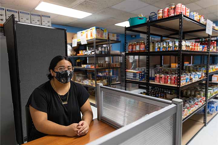 Yanet Reyes sits at reception area in food pantry