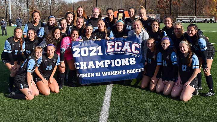 Women's soccer team holding ECAC Championship banner
