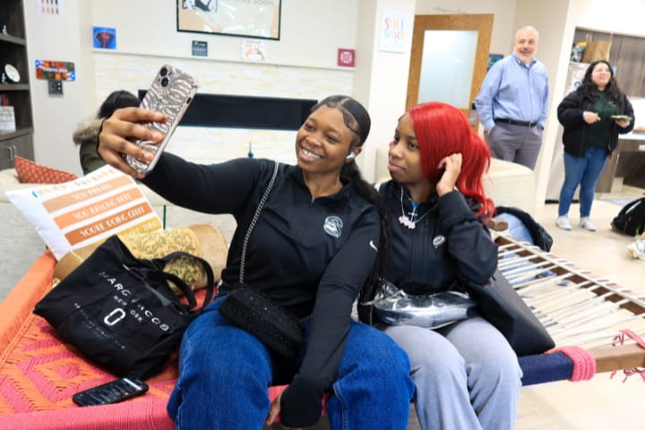 two students taking a selfie smiling