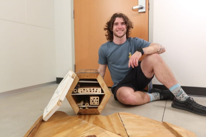 Liam Deibert next to his sculpture