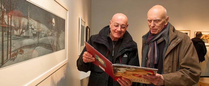 Older gentlemen looking at a book in the art gallery