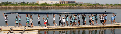 rowers carrying a boat to the water