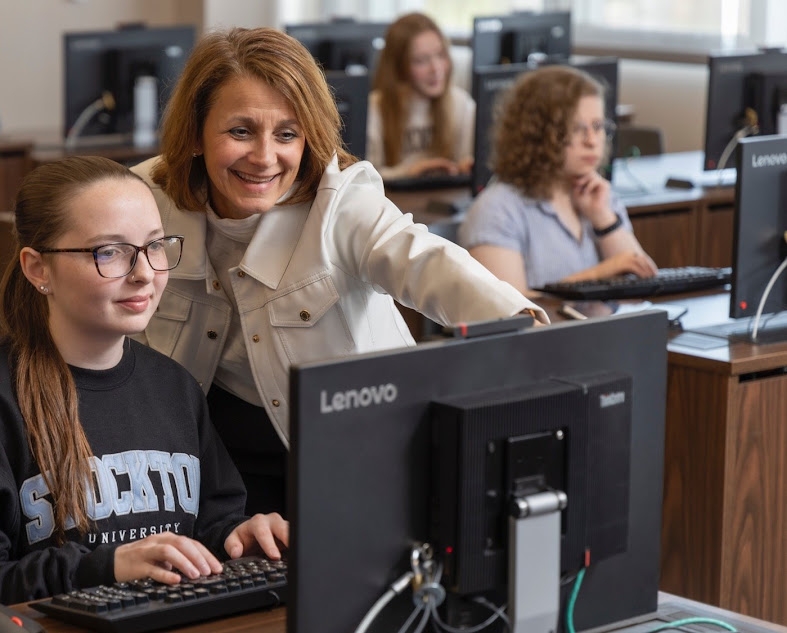 Donna Albano and student working on a computer