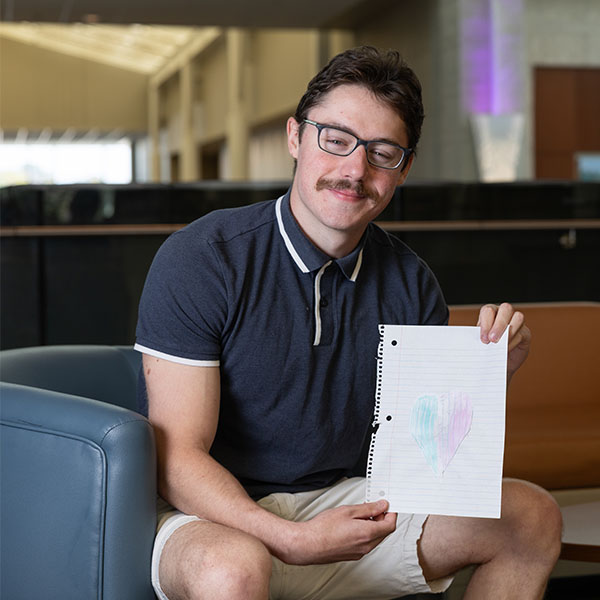 Domenic Buchanico '26 holds a drawing from one of the you he tutored in the Homework Completion Program.