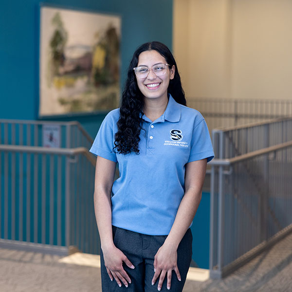 Keishla Sanchez smiles inside the John F. Scarpa School of Health Sciences building.