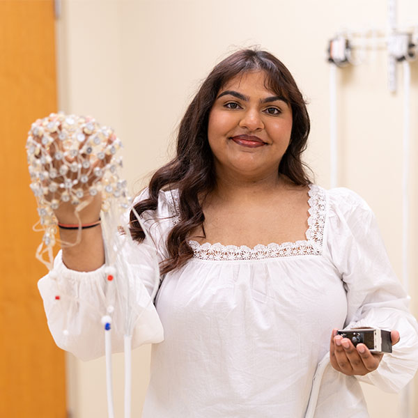 Tanya Sharma '26 holds a brain net in the EEG Lab.