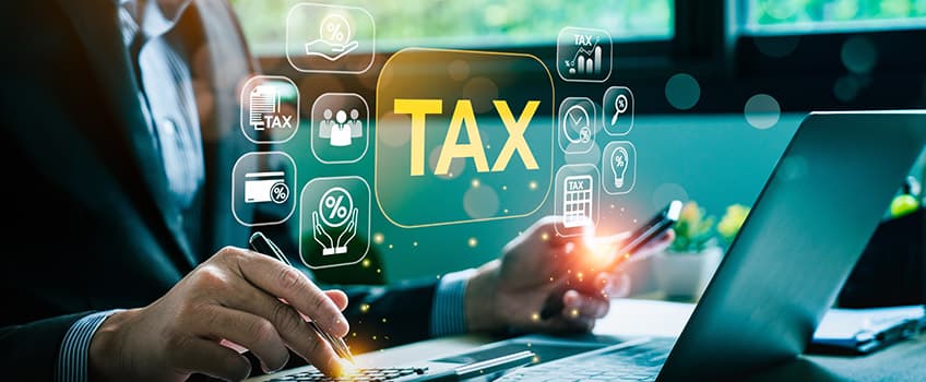 person using a laptop with tax icons layered on top of the photo
