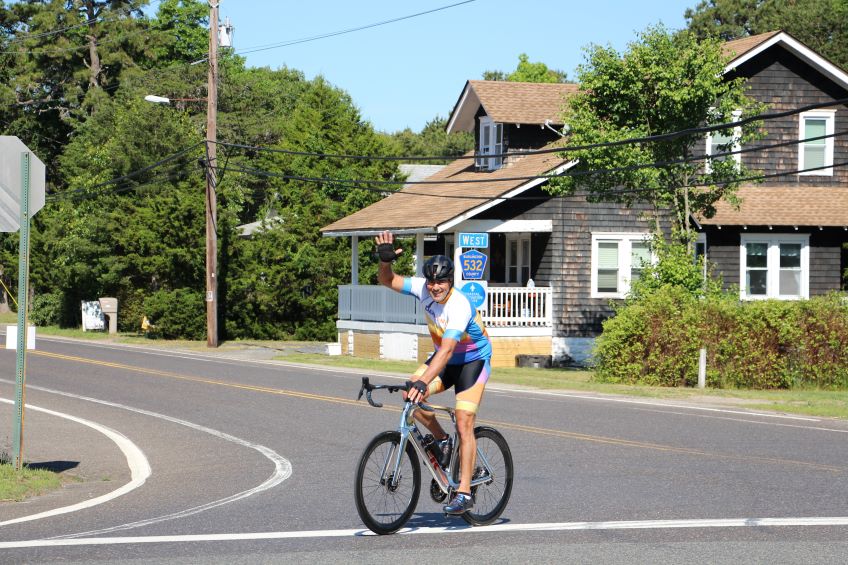 Cyclist waving while turning around at the halfway mark.