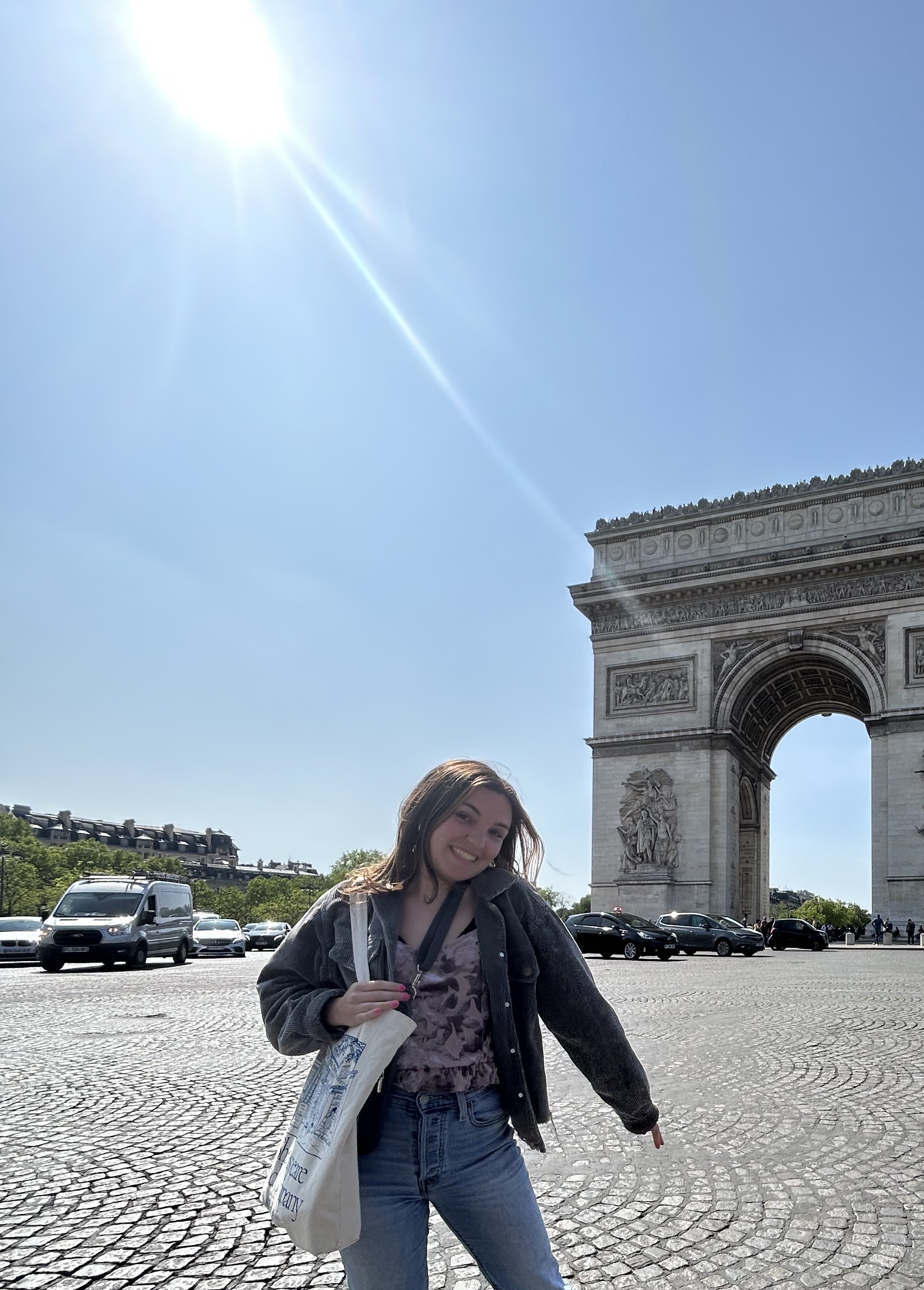 young woman standing out front of the Arc de Triomphe 