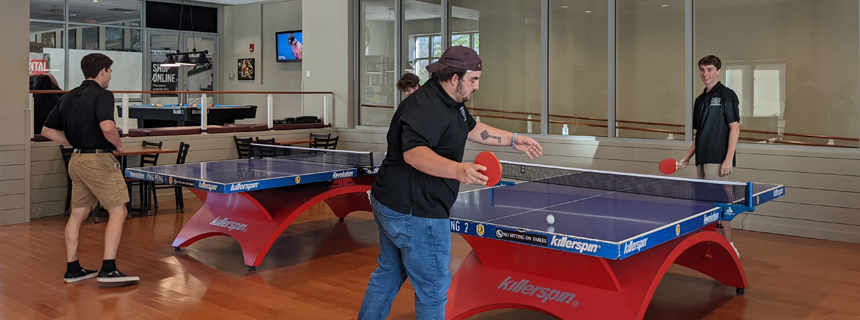 Student training in the game room playing ping pong Student training in the game room playing ping pong