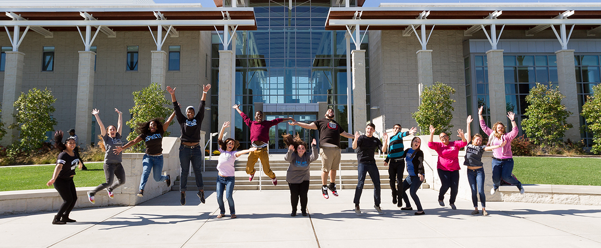 Students jumping in front of campus center Students jumping in front of campus center