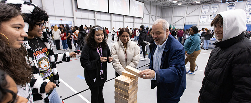 President Joe playing full size Jenga with some students in the Sports Center President Joe playing full size Jenga with some students in the Sports Center