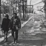 Black and White photo of two students walking the path through the wooded area pre destruction.