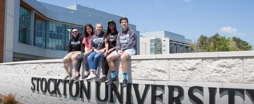 students sitting on sign in Academic Quad students sitting on sign in Academic Quad