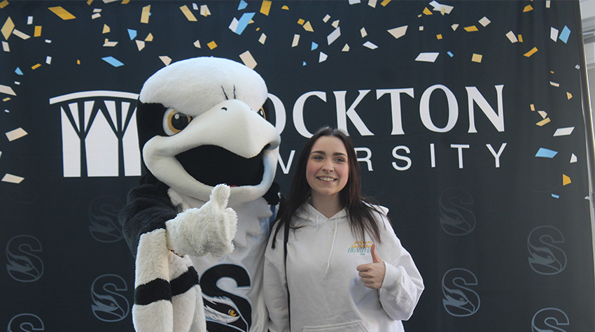 A prospective student and Talon in front of a Stockton background. A prospective student and Talon in front of a Stockton background.