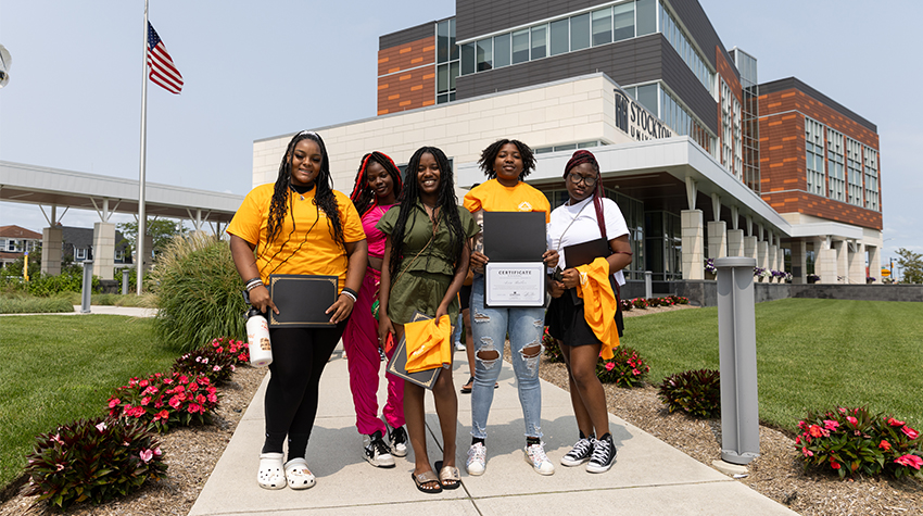Students in front of the AC Campus with their certificates and t-shirts Students in front of the AC Campus with their certificates and t-shirts