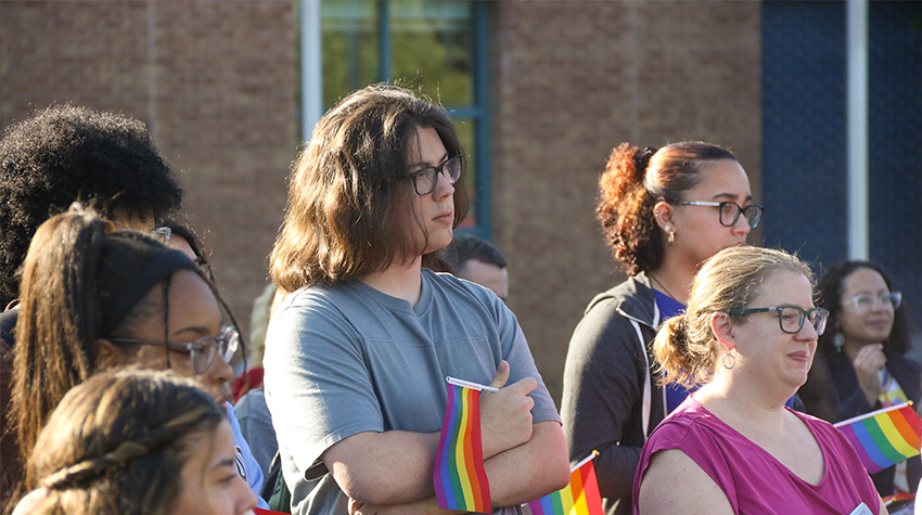 Students in attendance, holding rainbow flags Students in attendance, holding rainbow flags