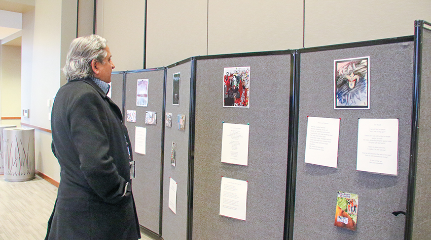 A faculty member looking at the artwork during the event A faculty member looking at the artwork during the event