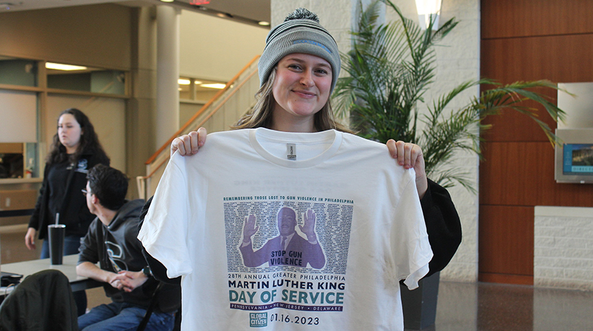 Brianna Bracey '23 holding up one of the free shirts volunteers received Brianna Bracey '23 holding up one of the free shirts volunteers received