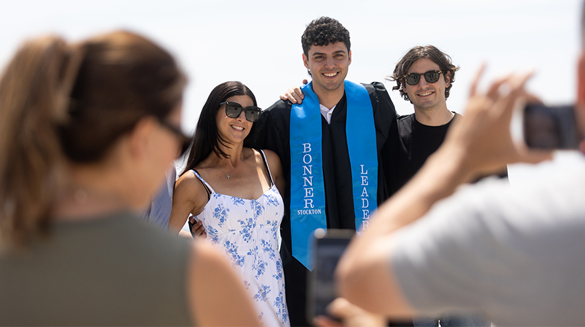 A student taking a photo with his friends after Commencement A student taking a photo with his friends after Commencement