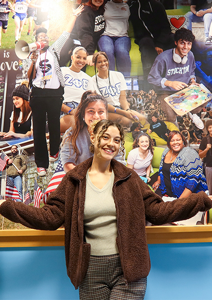 Yesenia in front of the F-100 hallway mural Yesenia in front of the F-100 hallway mural