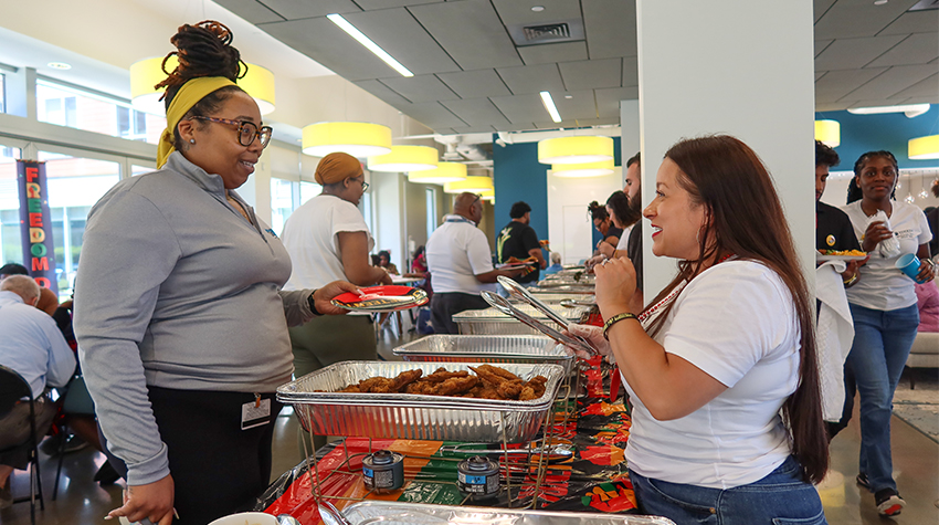 An attendee getting food from Jovin Fernandez, director of the Multicultural Center An attendee getting food from Jovin Fernandez, director of the Multicultural Center