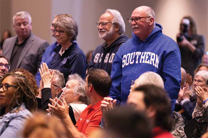 Members of Southern Connecticut State University's president's office stand in the crowd wearing their bright blue school colors Members of Southern Connecticut State University's president's office stand in the crowd wearing their bright blue school colors