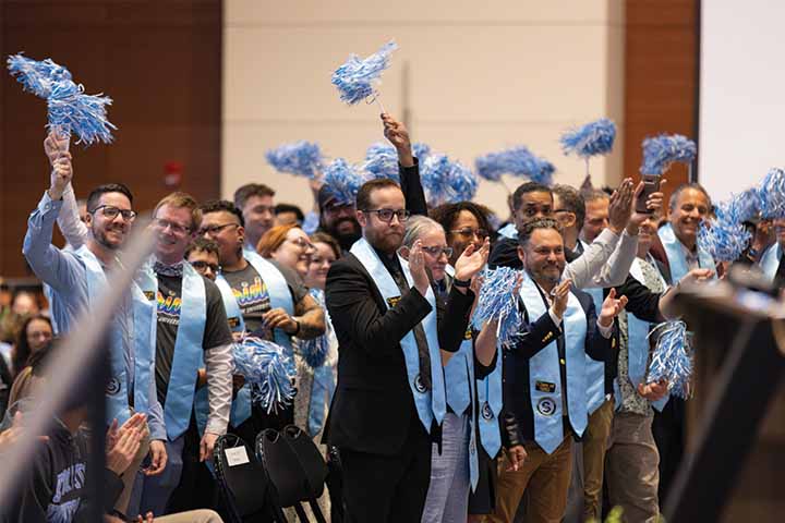 A group of Stockton alumni wear their Colombia blue stoles and wave Stockton pompoms in the Inauguration crowd A group of Stockton alumni wear their Colombia blue stoles and wave Stockton pompoms in the Inauguration crowd