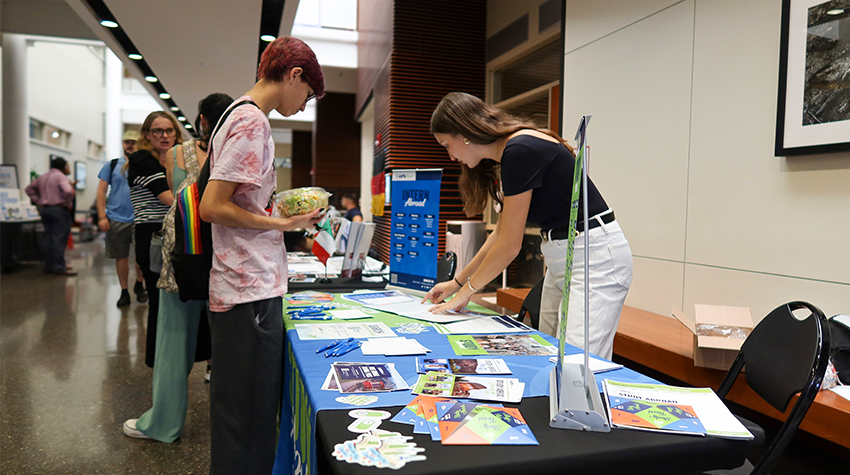 A student looking at one of the tables lining the hallway A student looking at one of the tables lining the hallway