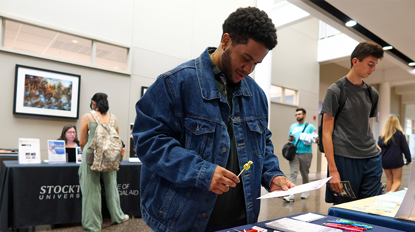 A student looking at one of the tables lining the hallway A student looking at one of the tables lining the hallway