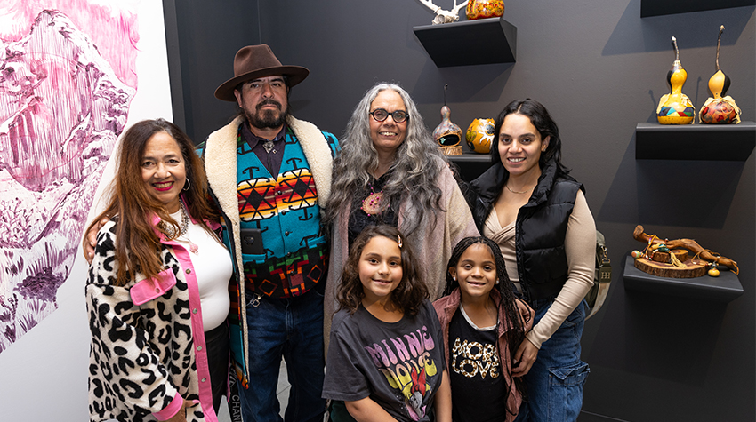 Tyrese "Bright Flower" Gould Jacinto and her family in front of her gourd art Tyrese "Bright Flower" Gould Jacinto and her family in front of her gourd art