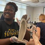 Student showing off the orthopedic shoe mold she just created.