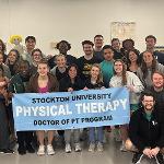 Students holding a Stockton Physical Therapy banner.