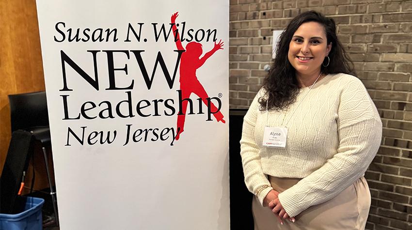 Alyssa in front of a banner bug that says "Susan N. Wilson NEW Leadership New Jersey" Alyssa in front of a banner bug that says "Susan N. Wilson NEW Leadership New Jersey"
