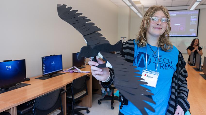 Tech Trek participant holding up an Osprey she made with paper Tech Trek participant holding up an Osprey she made with paper