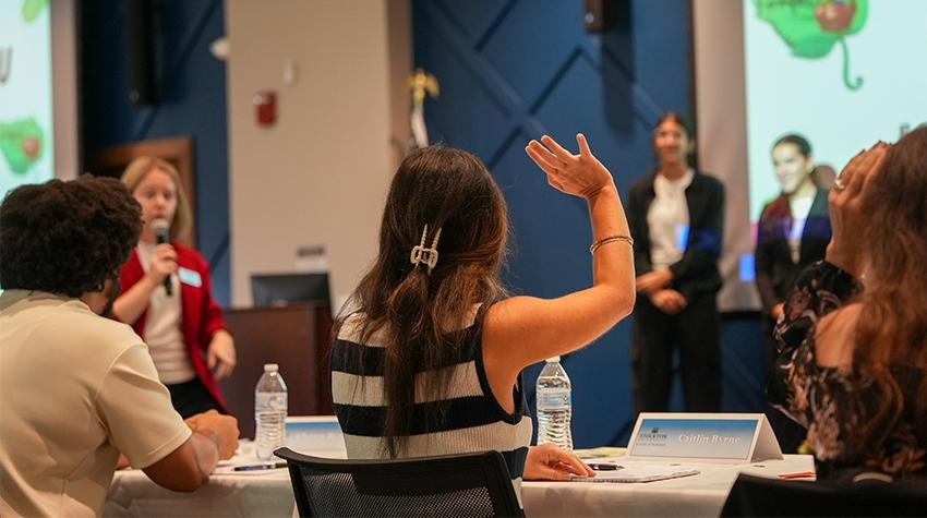 A judge raising her hand during a business presentation A judge raising her hand during a business presentation