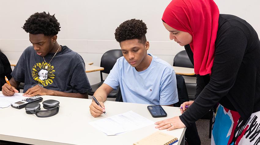 A professor helping with two EOF students in class A professor helping with two EOF students in class