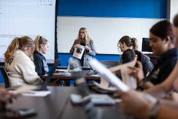 Communication Studies professor leads an interactive class discussion at Stockton University, guiding students through hands-on exercises in media and professional communication.