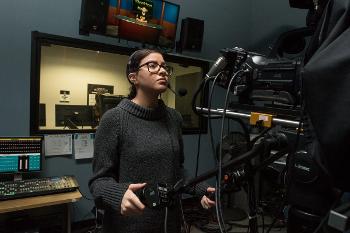 Student operates a studio camera in the campus TV lab, building film and broadcast skills.