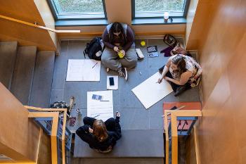 Art students collaborate on perspective drawings in a sunlit study space, bringing creativity into every corner of campus.