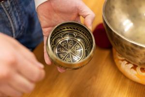 A student examines a Tibetan singing bowl during a Philosophy and Religion course exploring mindfulness and symbolism.