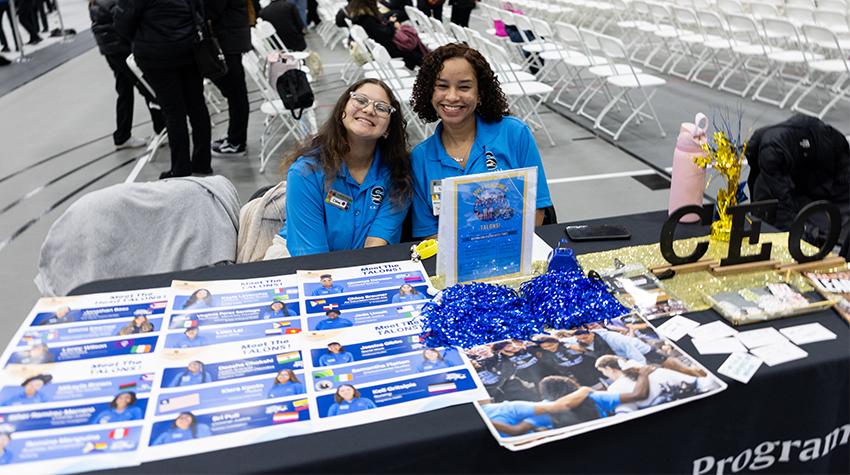 Admissions Ambassadors posing for a photo at their table Admissions Ambassadors posing for a photo at their table