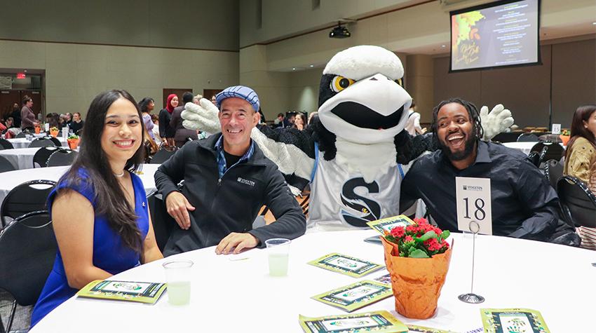 Two students, a faculty member and Talon the Osprey posing for a photo Two students, a faculty member and Talon the Osprey posing for a photo