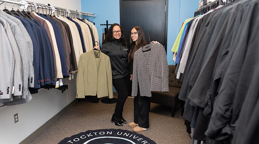 A student and a staff member posing for a photo inside of the new Suit Closet A student and a staff member posing for a photo inside of the new Suit Closet