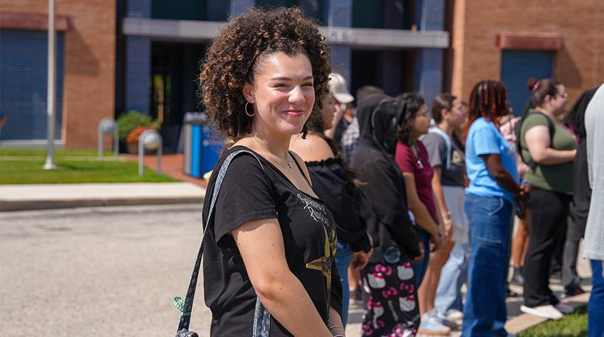 A student posing for a photo during a flag raising A student posing for a photo during a flag raising