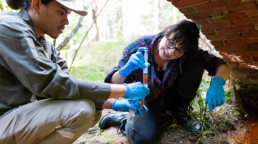 A faculty member and student exploring "pond guck" A faculty member and student exploring "pond guck"