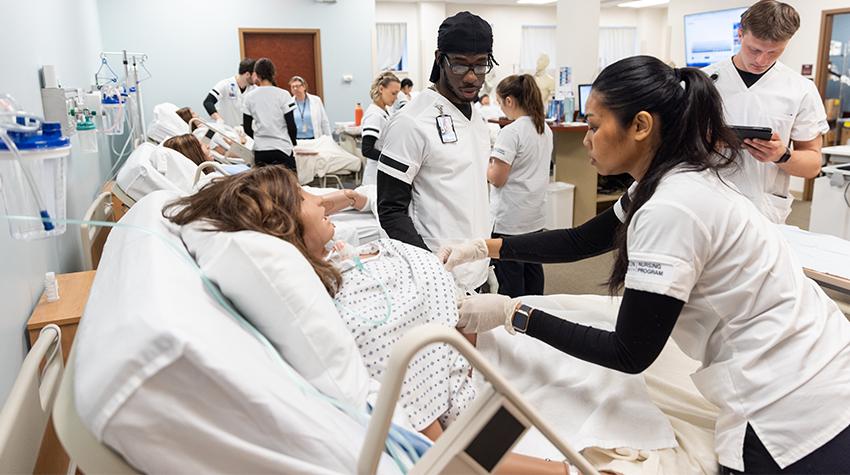Student nurses in a simulated lab Student nurses in a simulated lab