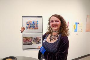 Student artist proudly displays her mixed-media portfolio during a campus art showcase highlighting student innovation. 